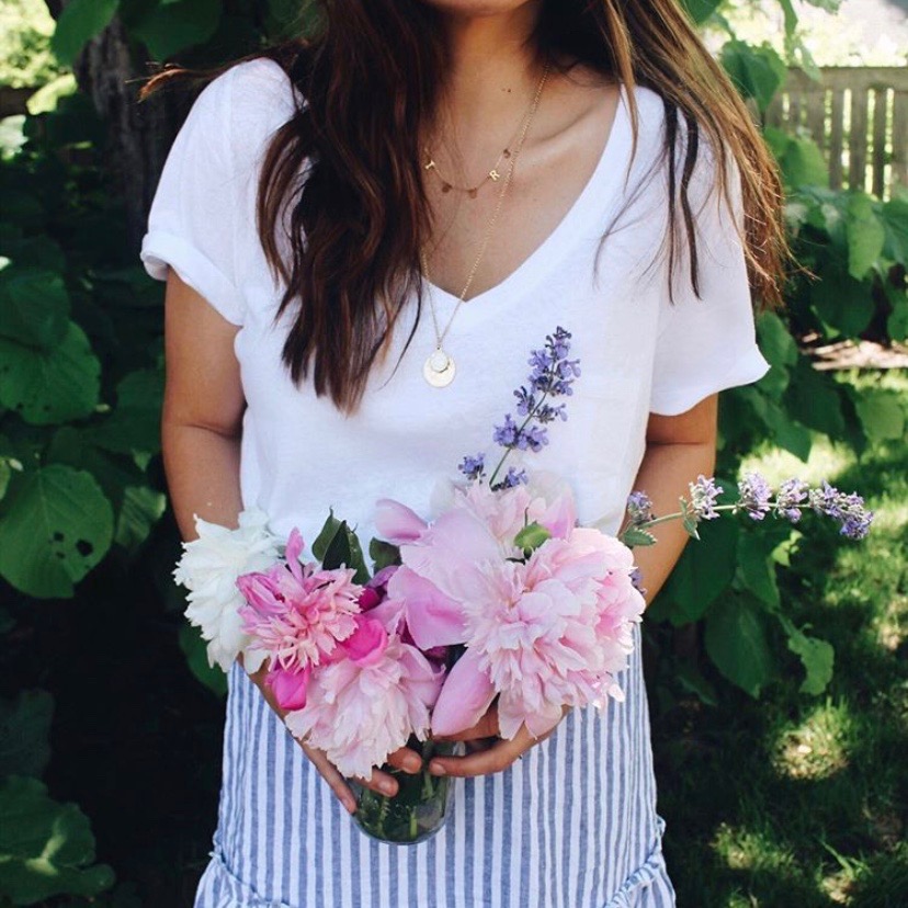 woman holding flowers, peonies, pink, layered necklace, garden